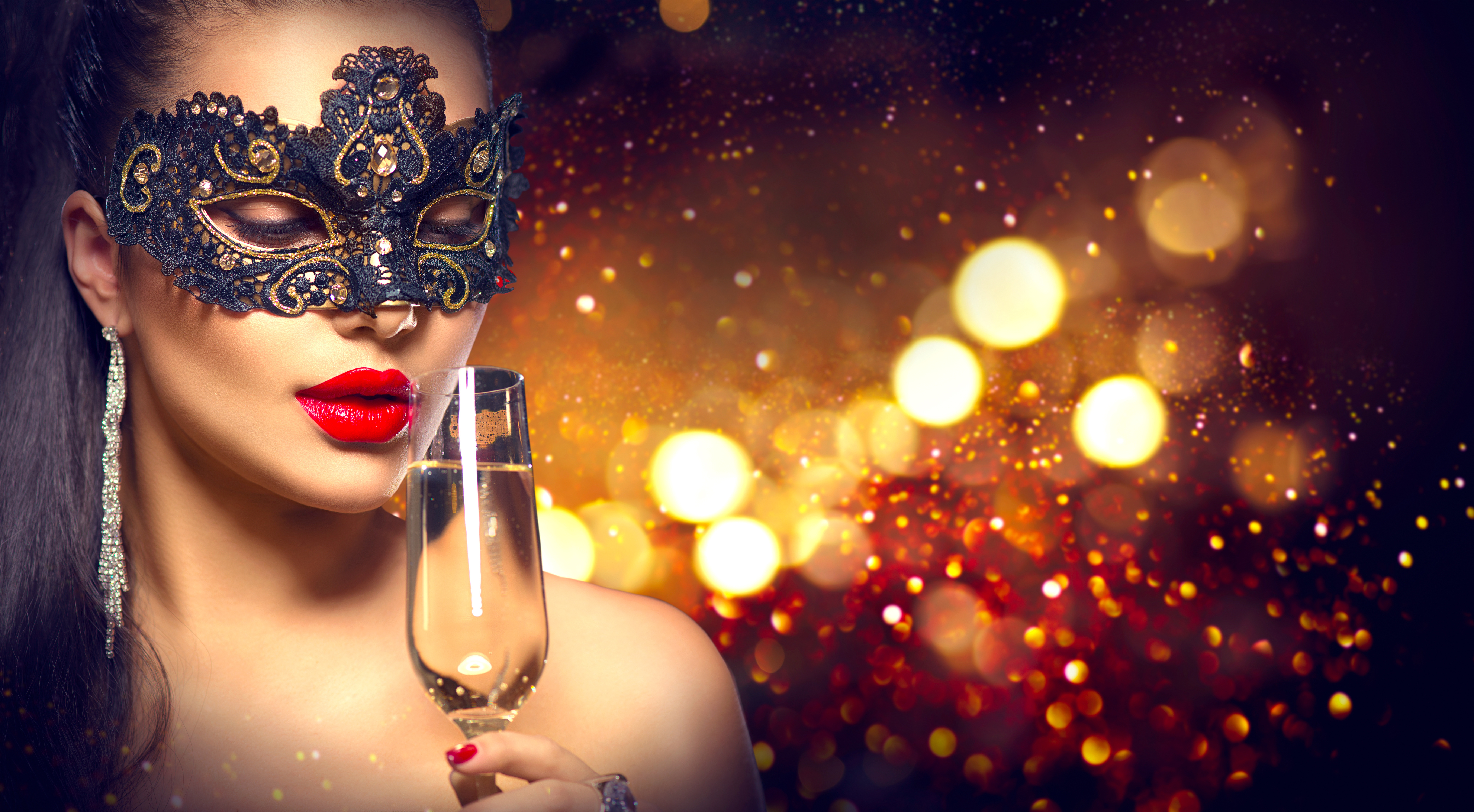Sexy model woman with glass of champagne wearing venetian masque